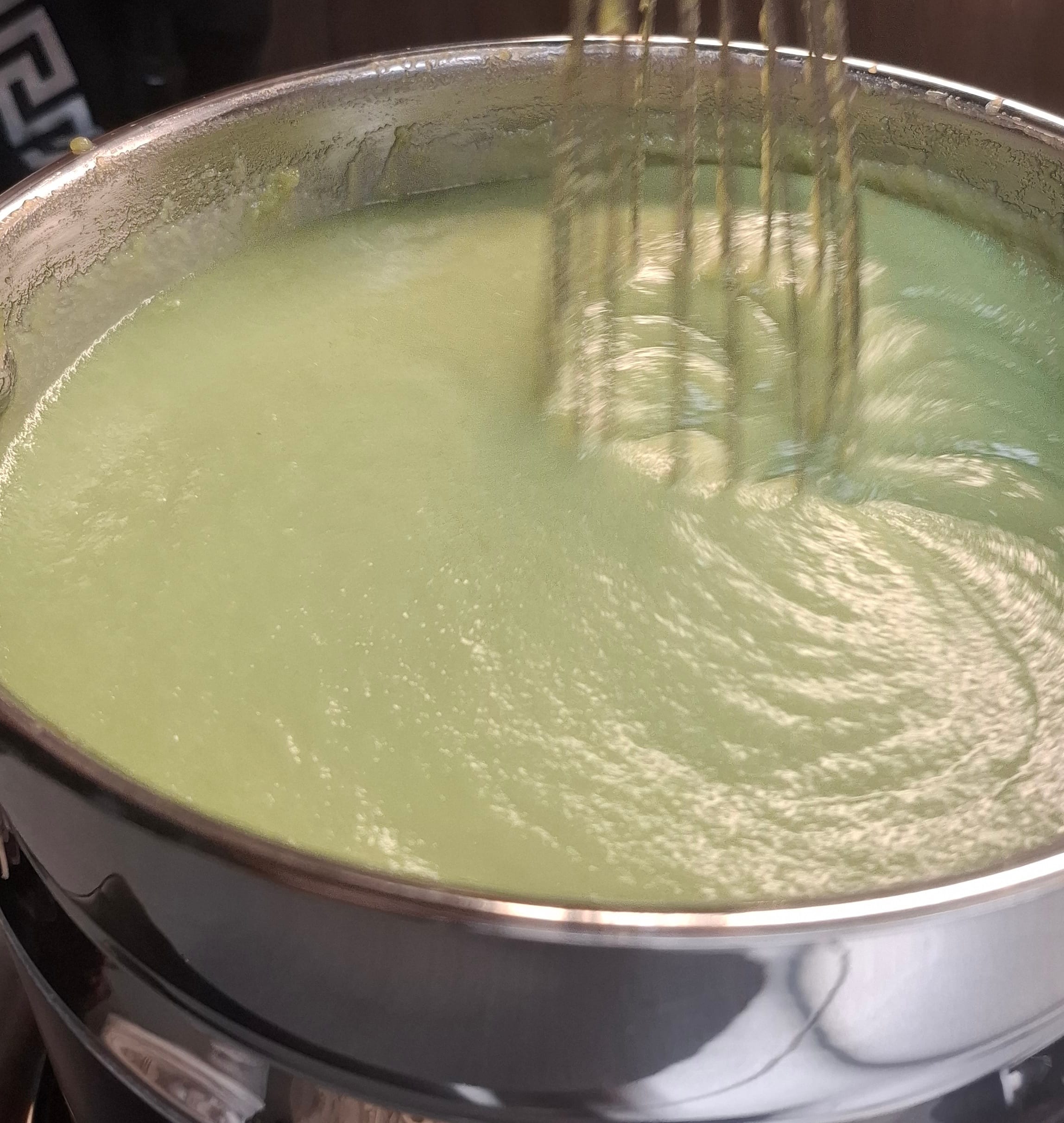 Spreadable kaya being constantly stirred in a circular motion in a double boiler
